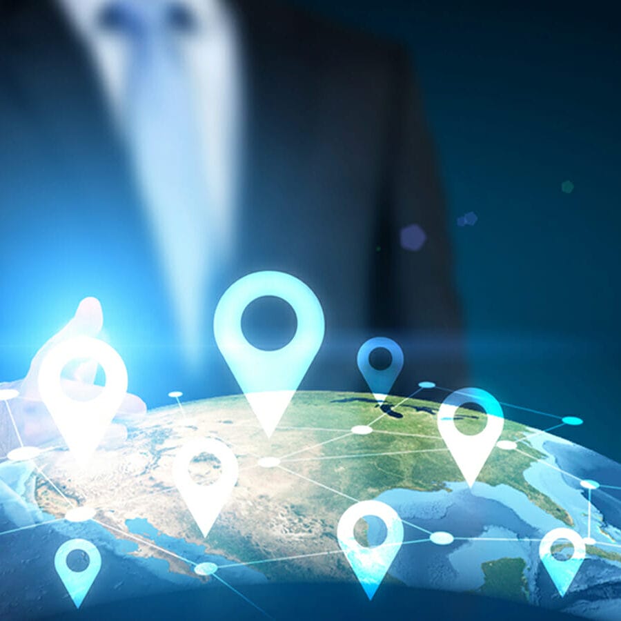 Traveling concept with businessman pointing at globe with location pin network on dark background | Phrase